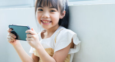 Asian child using smartphone at home