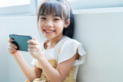 Asian child using smartphone at home