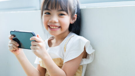 Asian child using smartphone at home